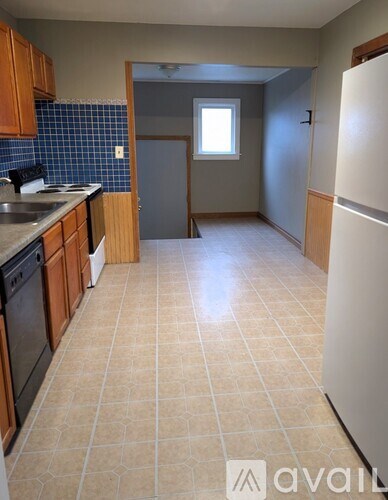 A kitchen with a white fridge and a blue tiled backsplash.