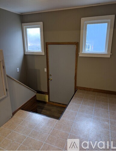 A room with a door and two windows.