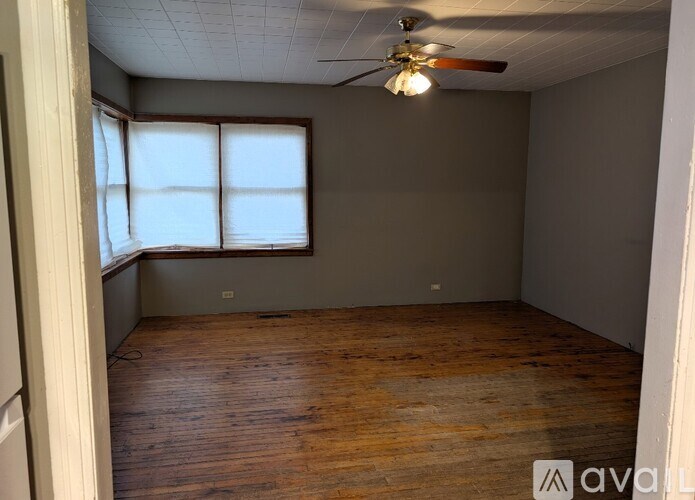 A room with wooden flooring and a ceiling fan.