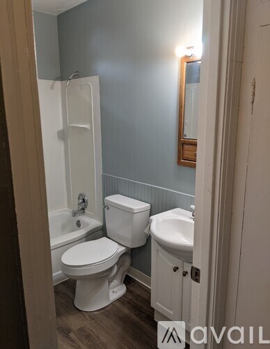 A bathroom with a toilet, sink and bathtub.