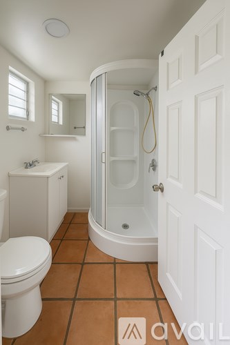 A bathroom with a toilet, sink, and shower.