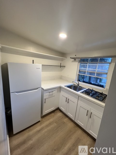 A kitchen with white appliances and cabinets.