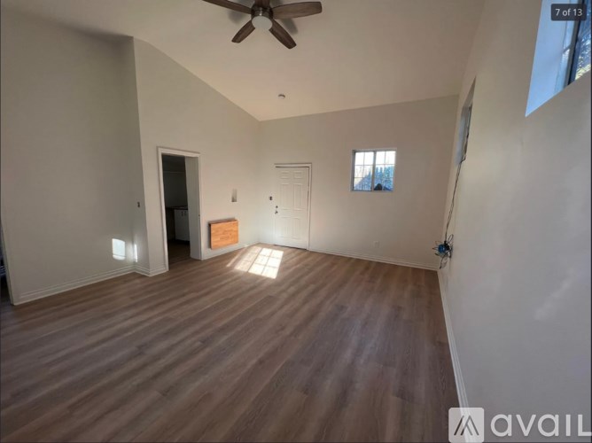 A room with wooden flooring and a ceiling fan.