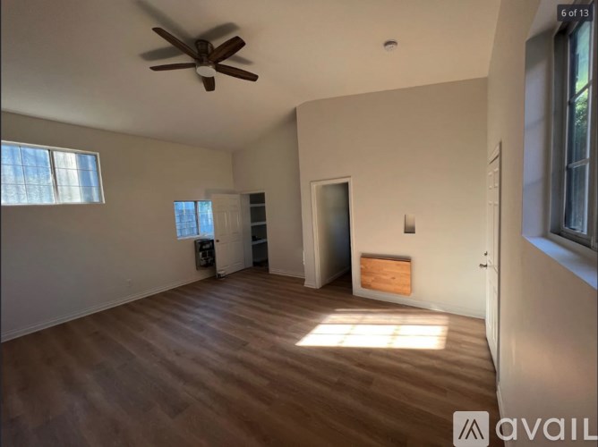 A room with a ceiling fan and wooden flooring.