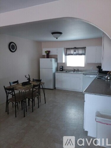 A kitchen with a table and chairs in the middle of the room.