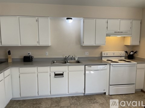 A kitchen with white cabinets and appliances.