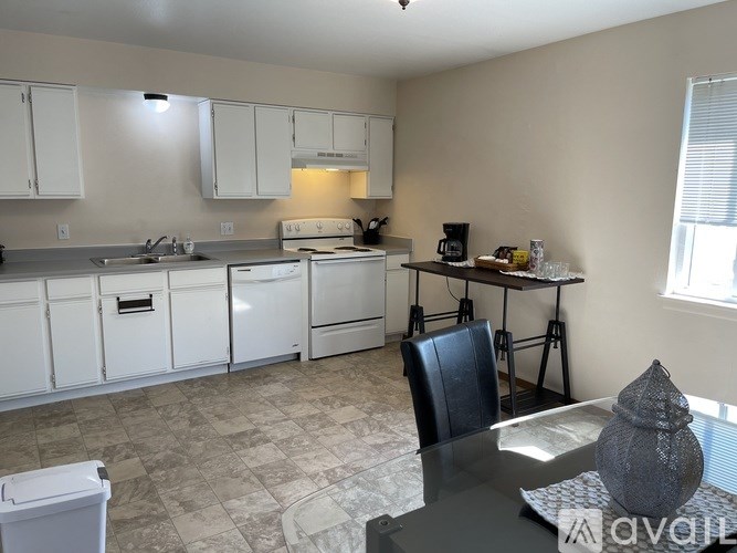 A kitchen with white cabinets and a tiled floor.