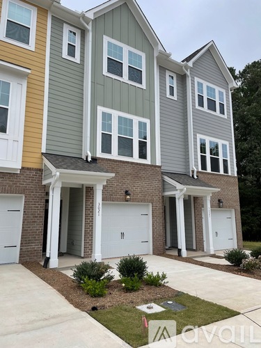 A row of houses with the first one being yellow, the second one being green and the third one being grey.