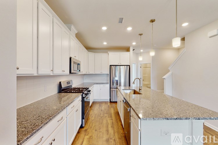 A kitchen with white cabinets and a granite countertop.