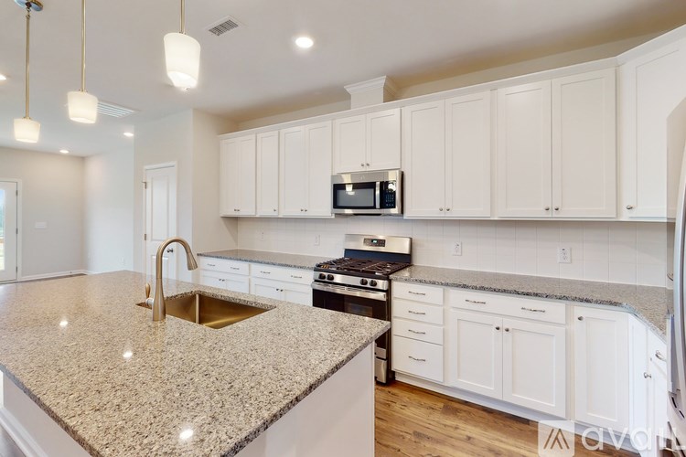 A kitchen with granite countertops and white cabinets.