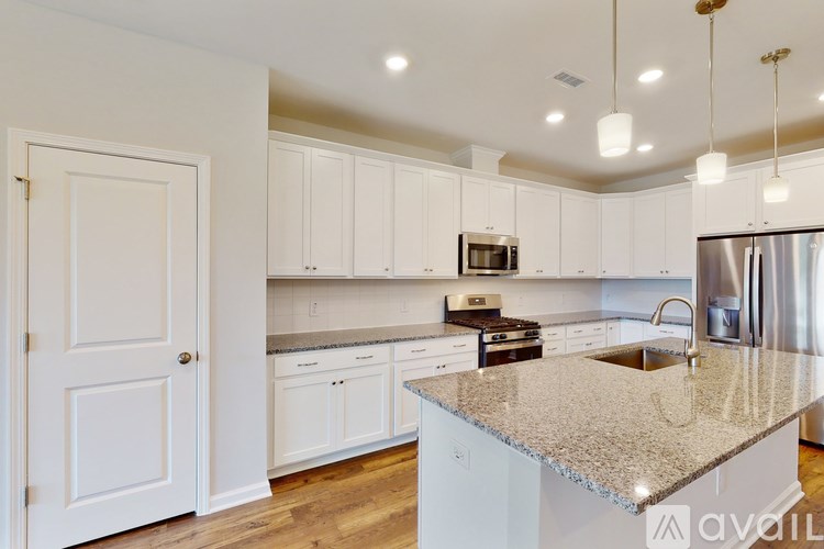A kitchen with white cabinets and a granite countertop.