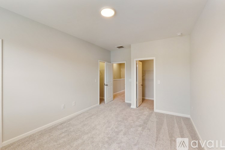 A spacious, empty room with a carpeted floor and white walls.