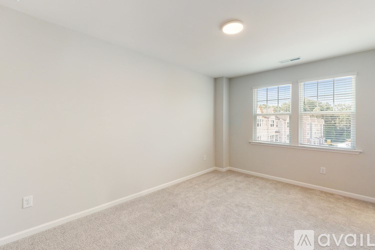 A room with a window and a carpeted floor.