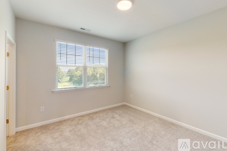 A room with a window and carpeted floor.