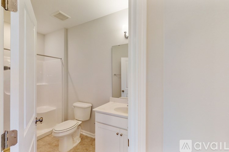 A white bathroom with a toilet, sink, and mirror.