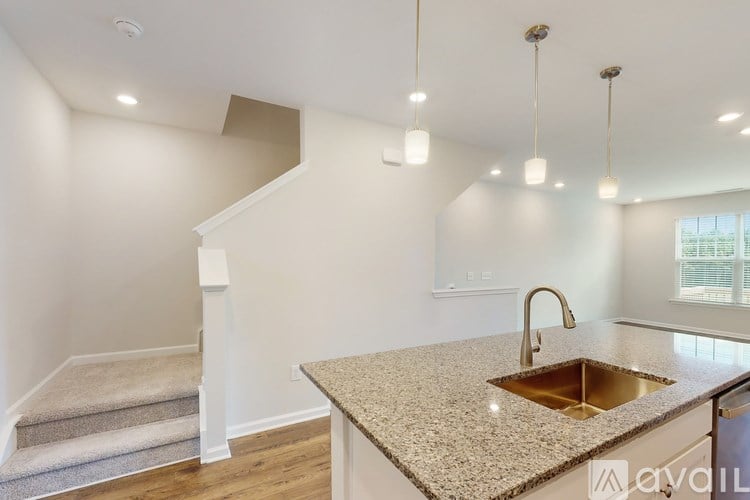 A kitchen with a granite countertop and a stainless steel sink.