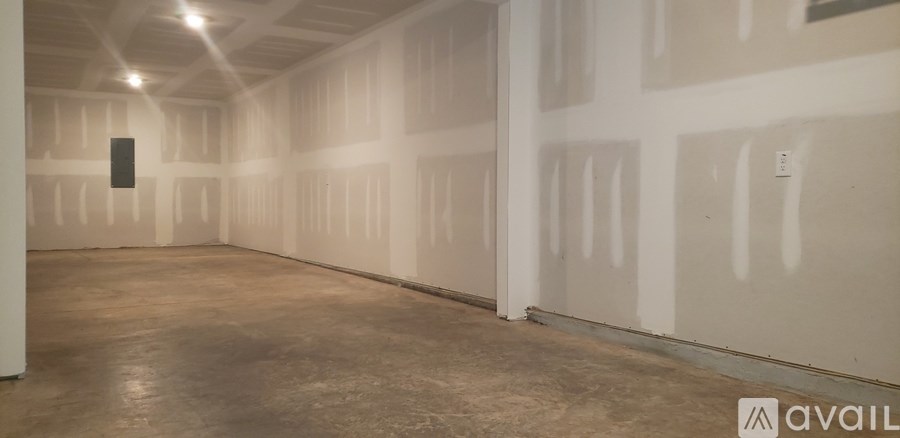 A large empty room with a concrete floor and white walls.