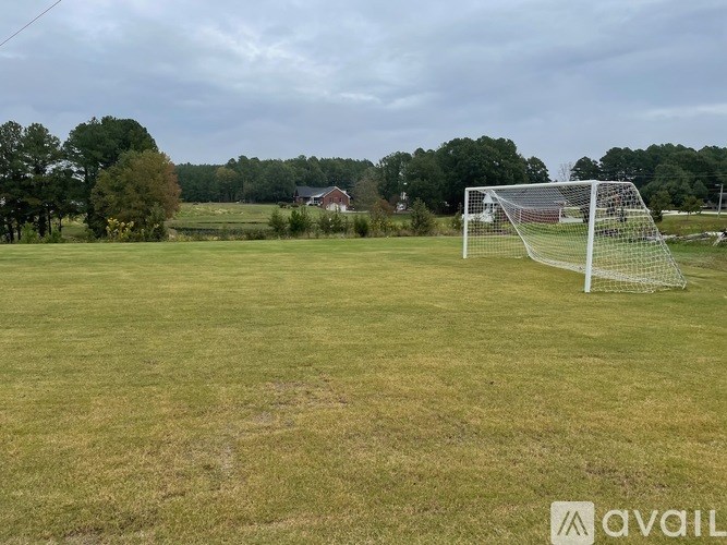A soccer goal stands in the middle of a grassy field.