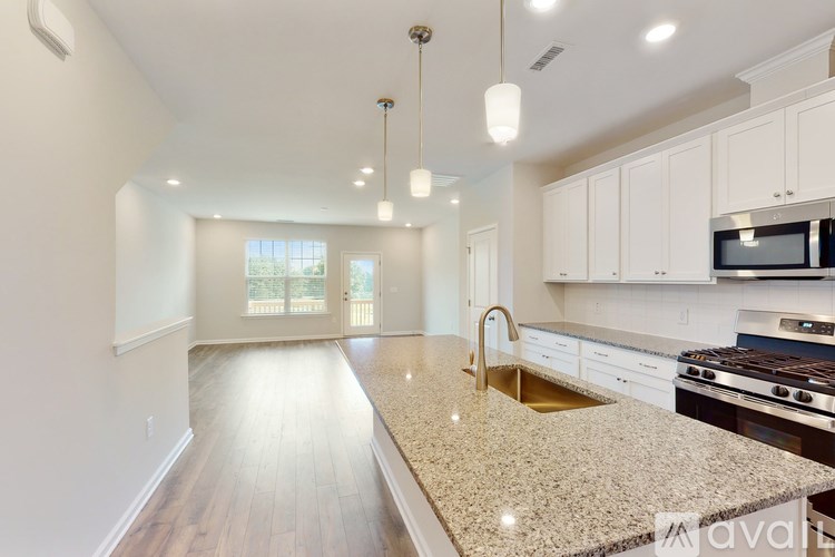 A kitchen with a granite countertop and stainless steel appliances.
