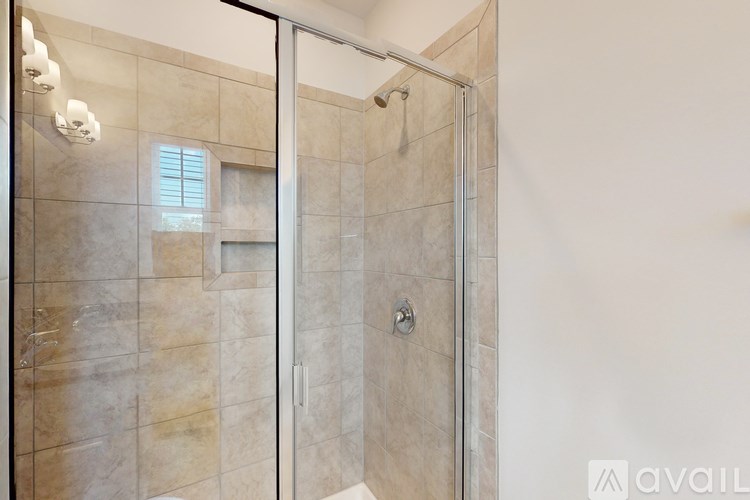 A bathroom with a walk-in shower and a window.