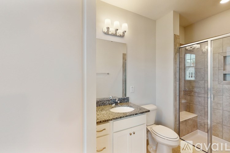 A bathroom with a toilet, sink, and mirror.