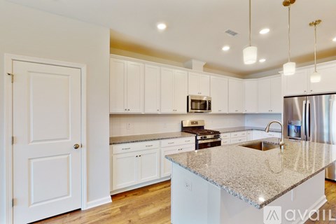 A kitchen with white cabinets and a granite countertop.