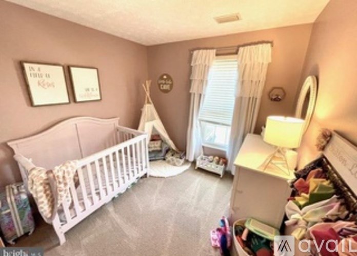 A baby's room with a white crib and a teepee.