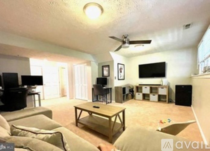 A living room with a couch, a coffee table, and a television.