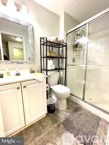 A bathroom with a toilet, sink, and mirror.