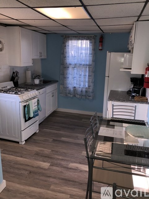 A kitchen with a white stove and wooden floors.
