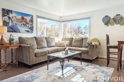A living room with a couch, chair, and a painting on the wall.