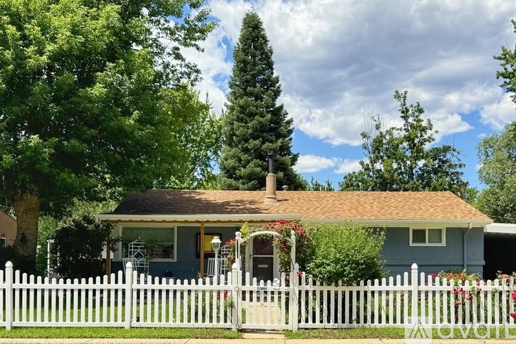 A house with a white picket fence in front.