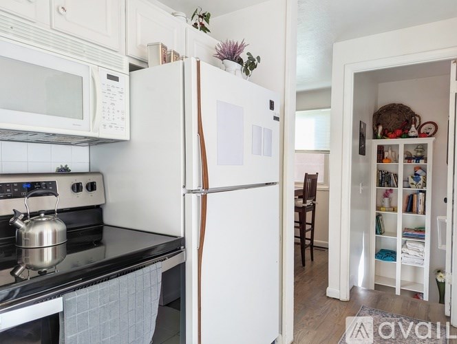 A kitchen with a white refrigerator and a black stove.