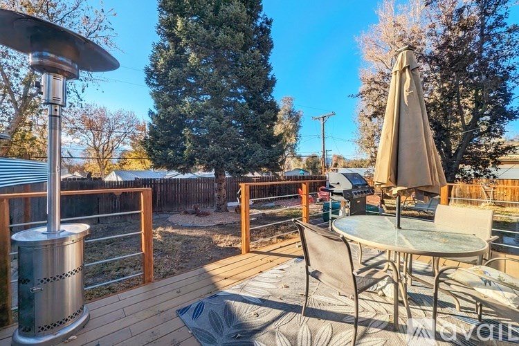 A patio with a table, chairs, and an umbrella.