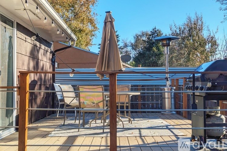 A patio with a table and chairs under a large umbrella.