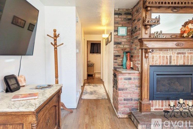 A living room with a fireplace and a TV on the wall.