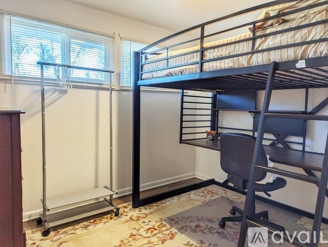 A bunk bed in a room with a chair and a table.