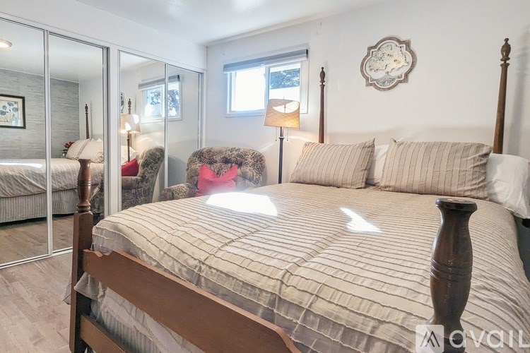 A bedroom with a large bed and a mirror on the wall.