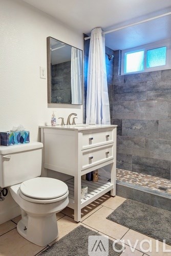 A white toilet sits next to a white sink in a bathroom.