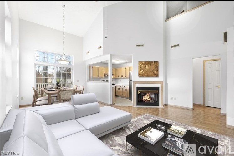 A modern living room with a grey sofa and a fireplace.