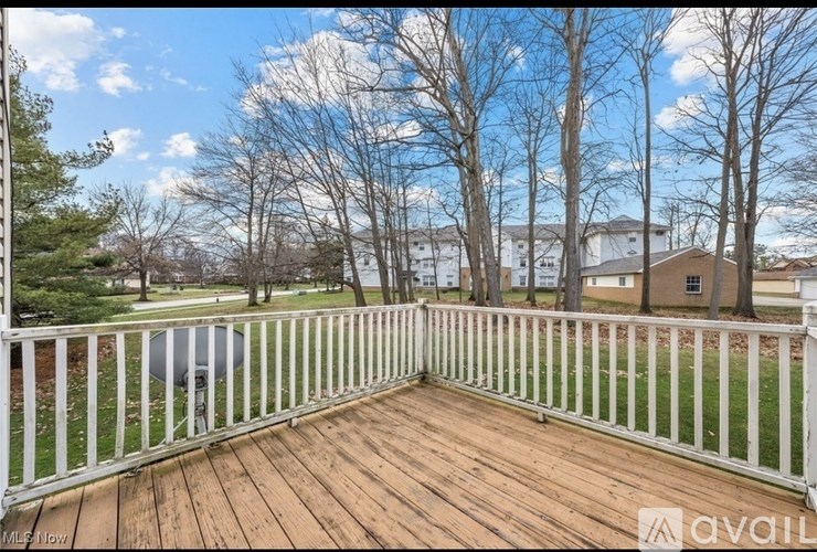 A deck with a white railing and a pool in the background.