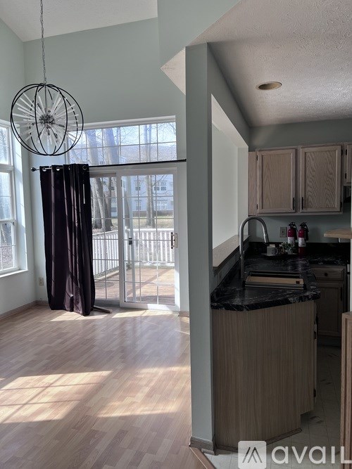 A kitchen with wooden floors and a black countertop.
