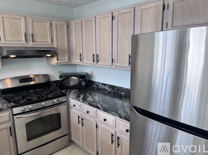 A kitchen with a stainless steel refrigerator, oven, and cabinets.