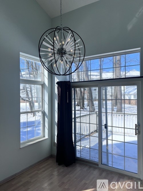 A room with a large window and a view of a snowy landscape outside.