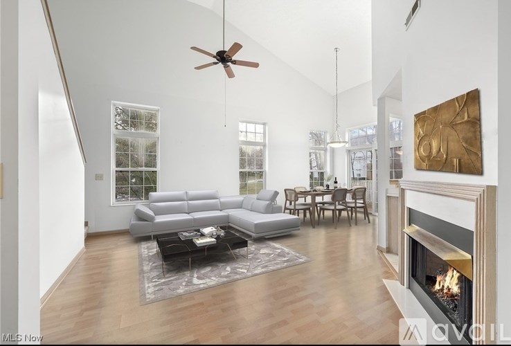 A modern living room with a fireplace and a grey sofa.