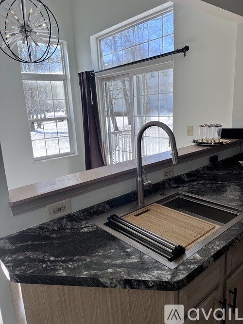A kitchen with a black granite countertop and a window.
