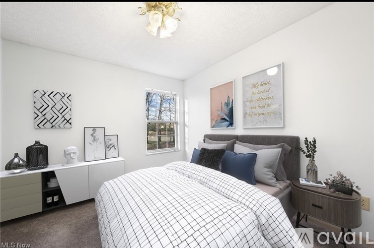 A bedroom with a bed, nightstand, and a chandelier.
