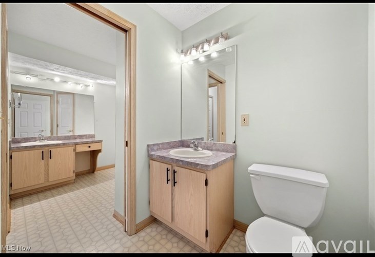 A bathroom with a sink, toilet, and mirror.