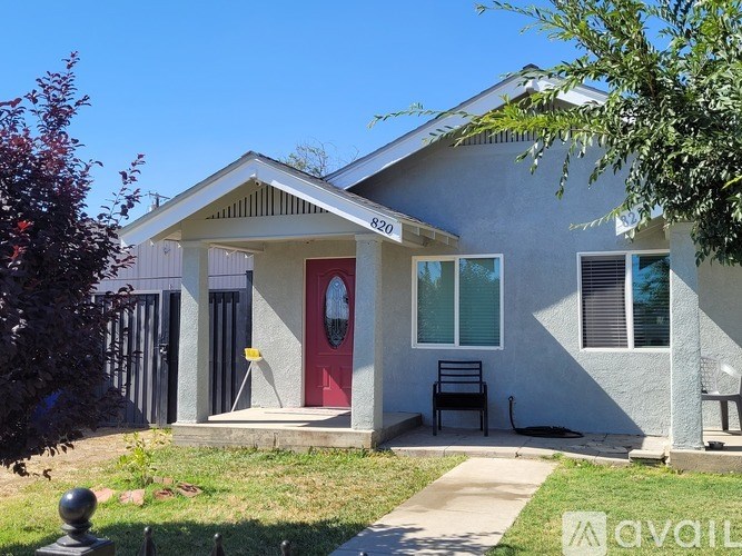A house with a red door and a mailbox on the front porch.