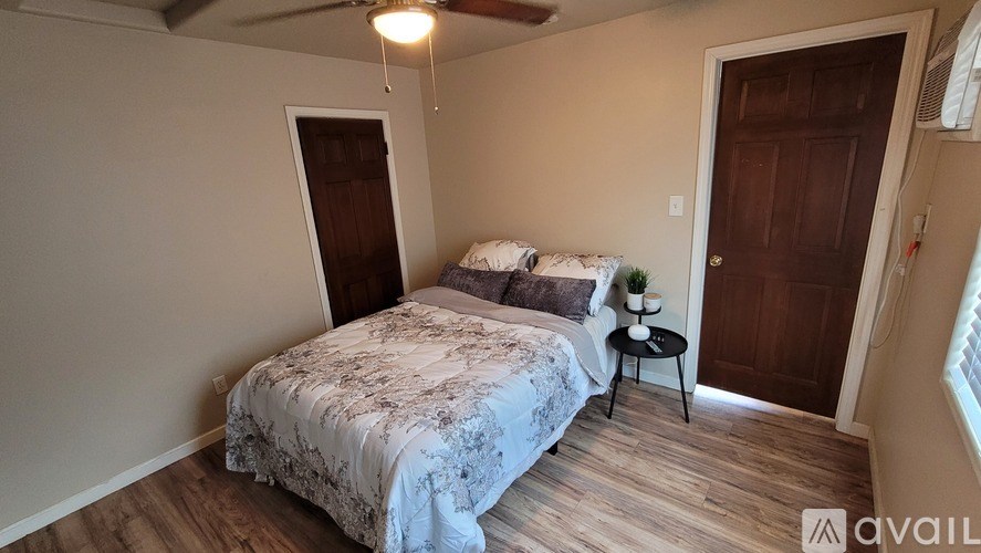 A bedroom with a bed, nightstand, and a ceiling fan.
